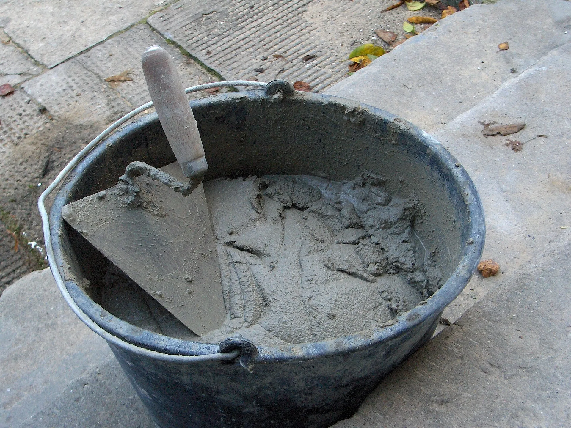 Trowel resting in a bucket of mortar
