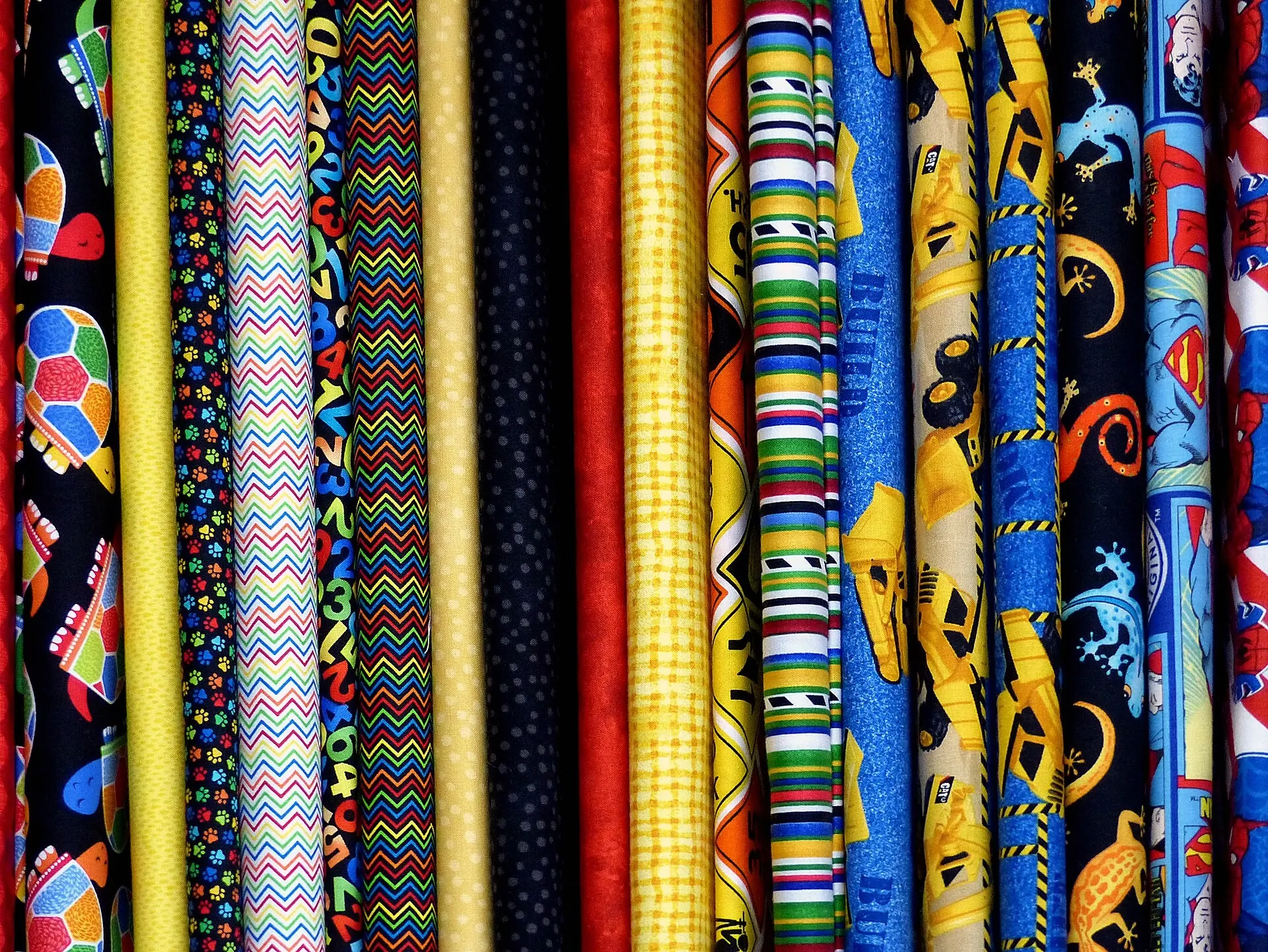 Bolts of patterned fabric standing side by side