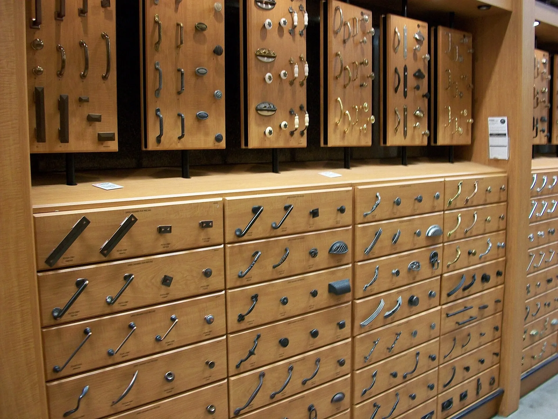 Display of cabinet handles and knobs on drawer fronts