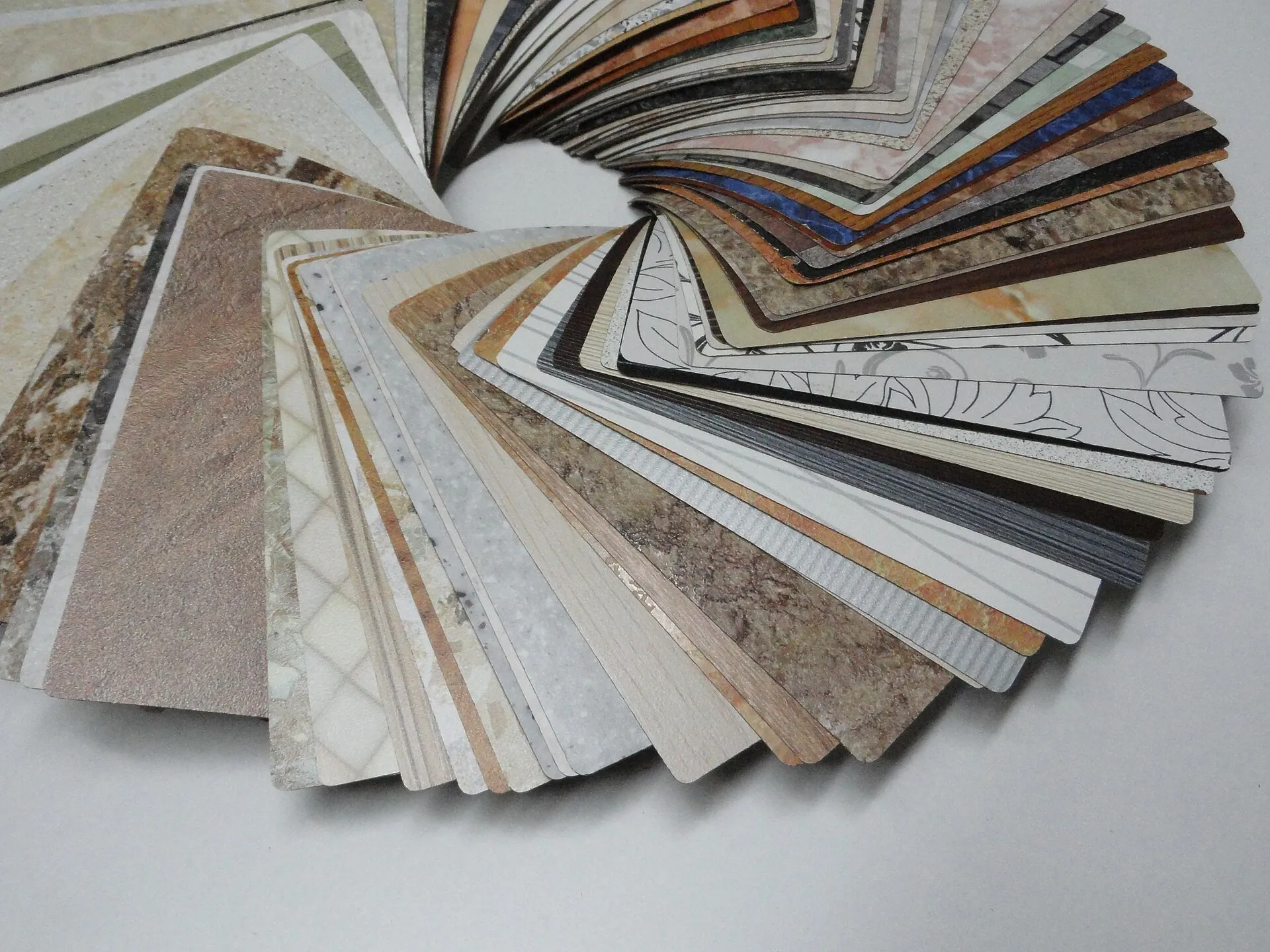 Fan of decorative laminate samples in stone and wood finishes