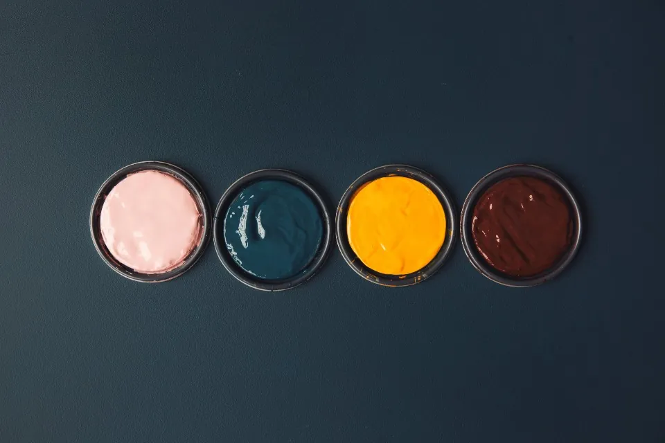 Four open tins of paint seen from above